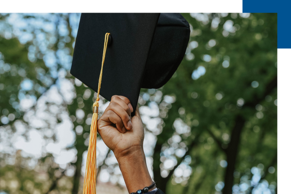 graduate holding up a cap