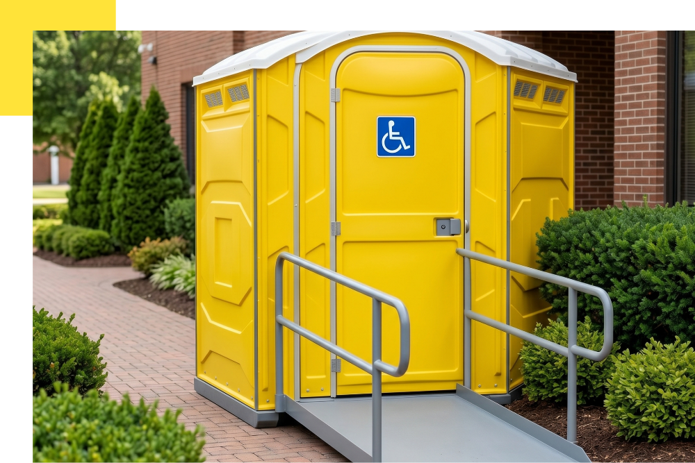 An immaculate, wheelchair-accessible (ADA compliant) portable restroom unit, featuring a ramp and a visible blue accessibility logo on the door. It is placed on a paved walkway within a landscaped courtyard in Bridgeton, Michigan, showcasing hygiene and accessibility.