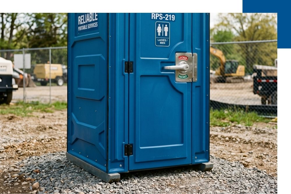 A close-up, high-quality photograph of a single, gleaming portable restroom unit on a stable gravel base, emphasizing its cleanliness, locking handle, and reliable construction.